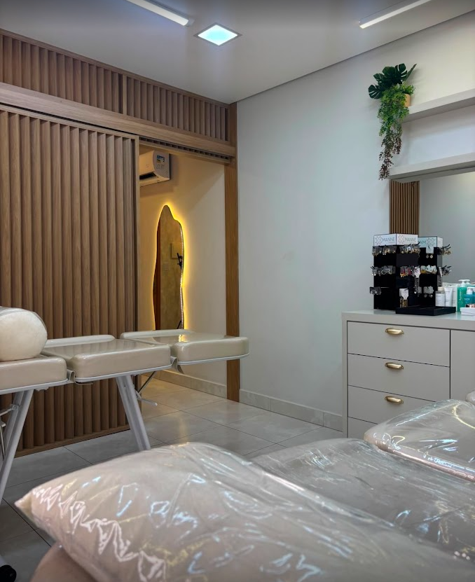 Sala de atendimento da AD Beauty com macas, parede ripada e iluminação suave