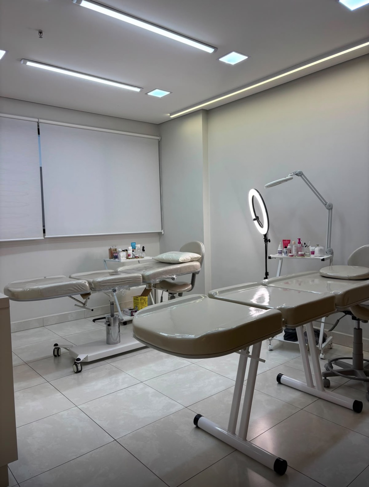 Sala da clínica com macas, ring light e lupa de atendimento